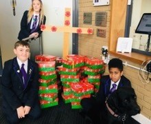 Students with boxes by cross